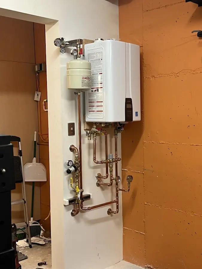 Plumbing technician inspecting water heater connections in Neversink